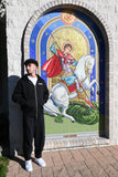 Saint George zip-up hoodie in black, worn in front of the Saint George icon